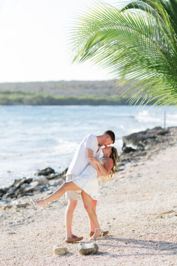 A couple poses for photos at their desitnation wedding welcome party at Sandals Royal Curacao